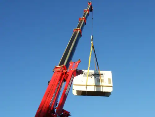 Power continuity 100 kVA diesel generator being lifted by a crane