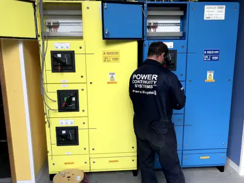 Power continuity engineer maintaining a yellow ups and blue ups