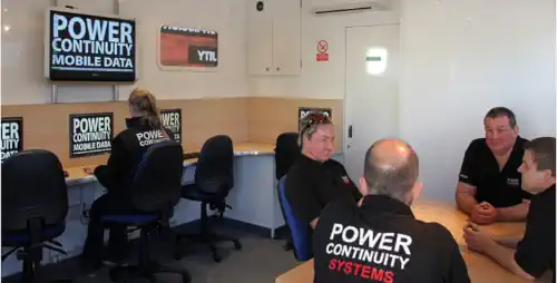 Power continuity engineers gathered in a mobile data centre
