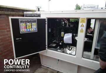 Power continuity engineers servicing canopied diesel generator