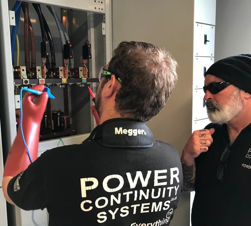 Power continuity engineers working on a lv mains panel