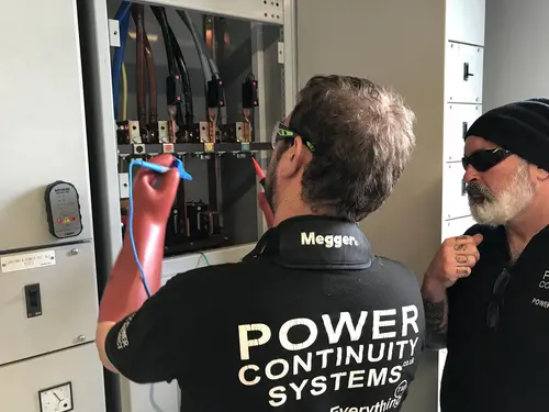Power continuity engineers working on a lv mains panel